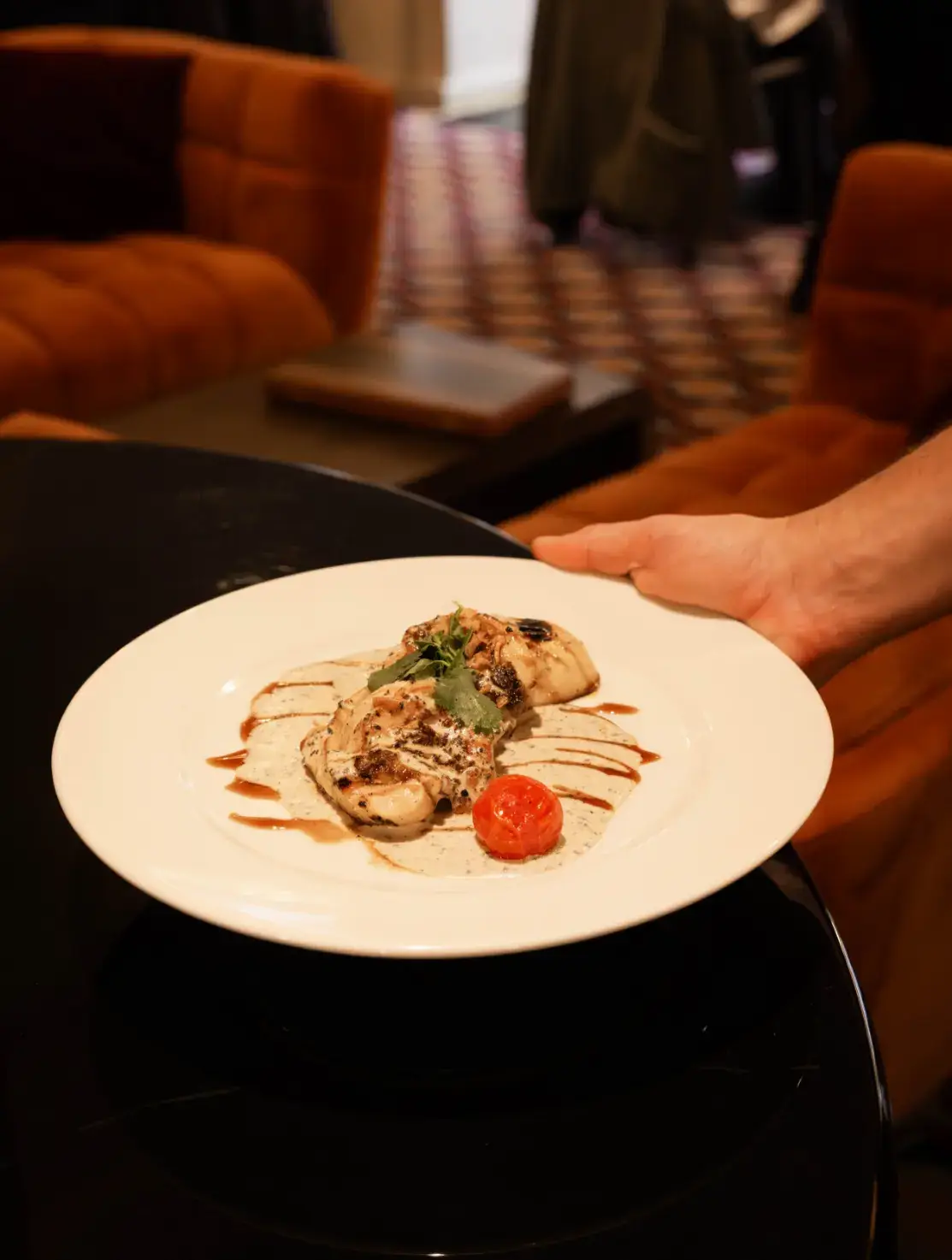 Plat de volaille grillée servie avec sauce crémeuse et tomate confite au restaurant Madie.